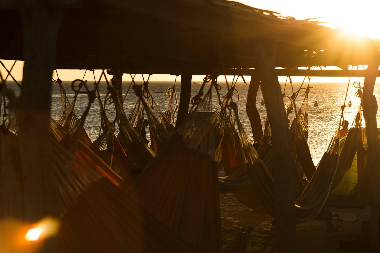 Assorted-color hammocks under wooden shed beside sea