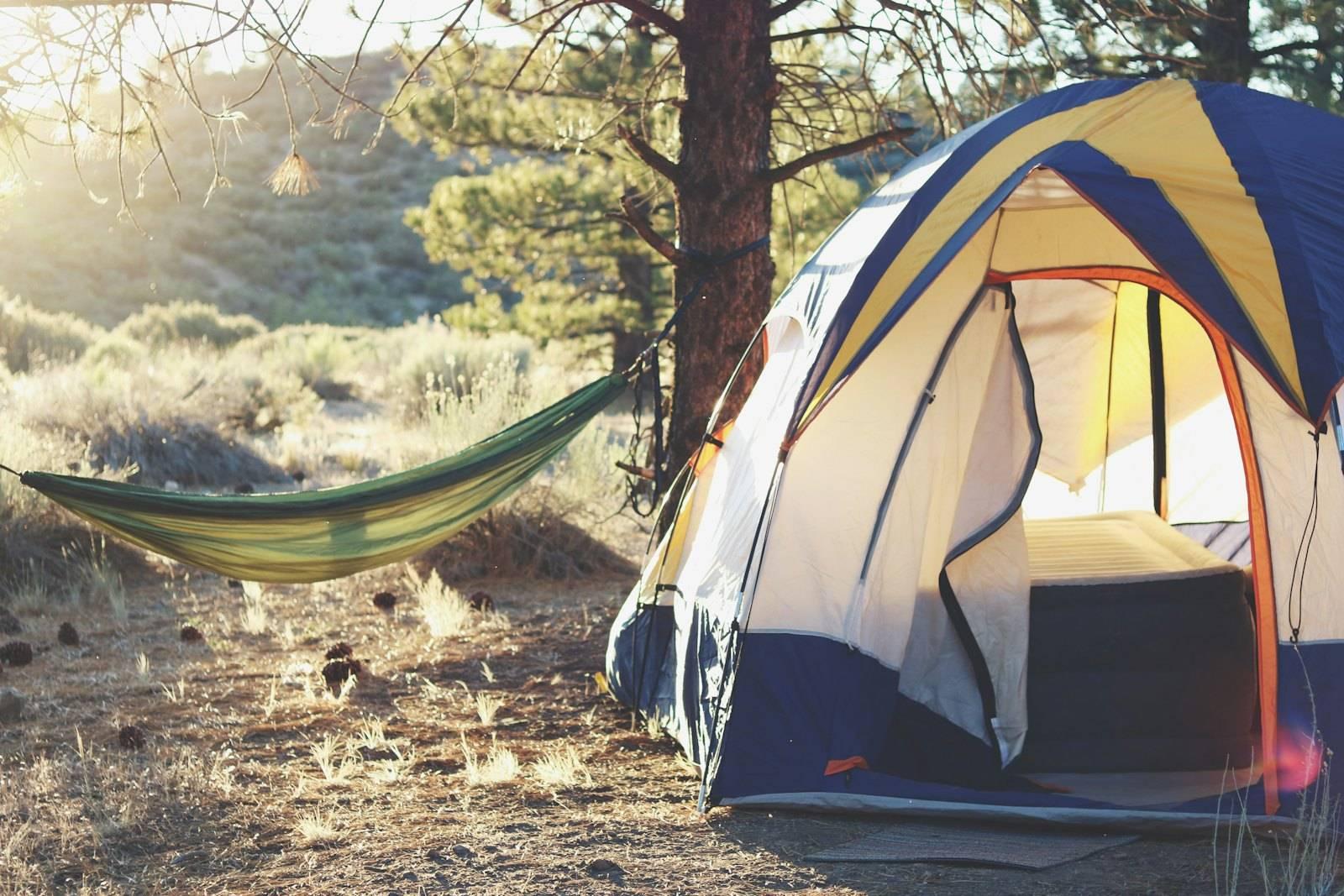 White, yellow, and blue dome tent near green hammock